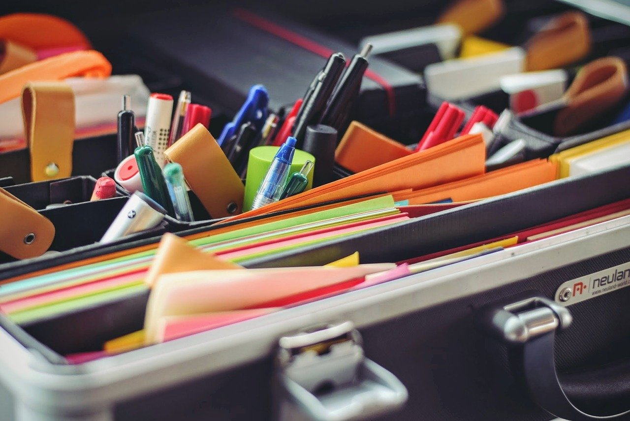 A desk organiser with lots of paper and pens